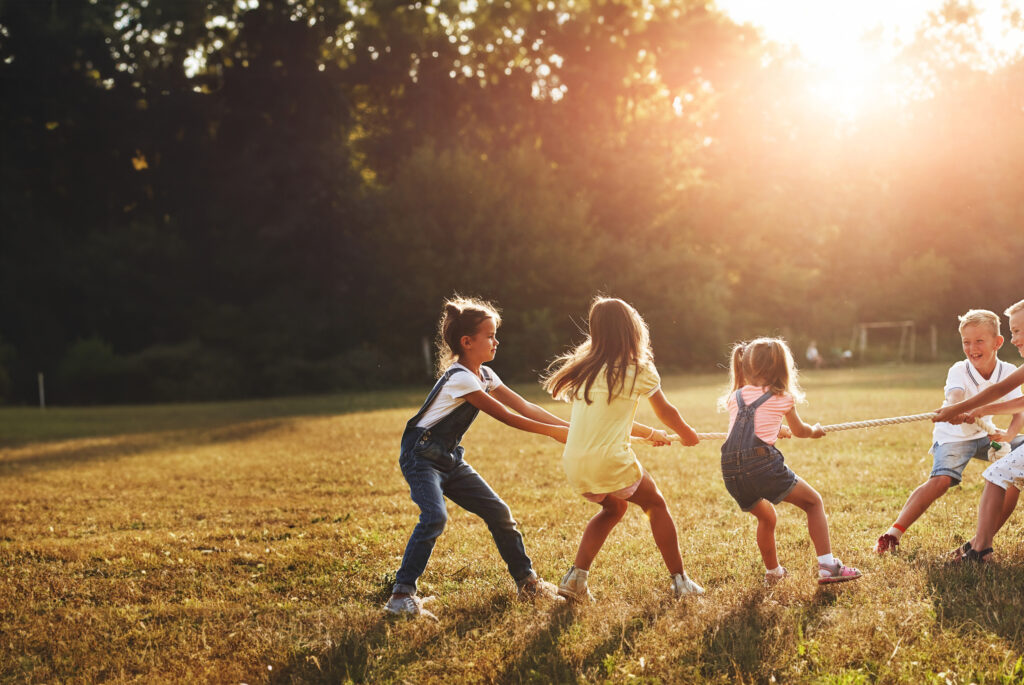 kids-playing-tug-war-game-beautiful-meadow-sunny-day-BEWERKT